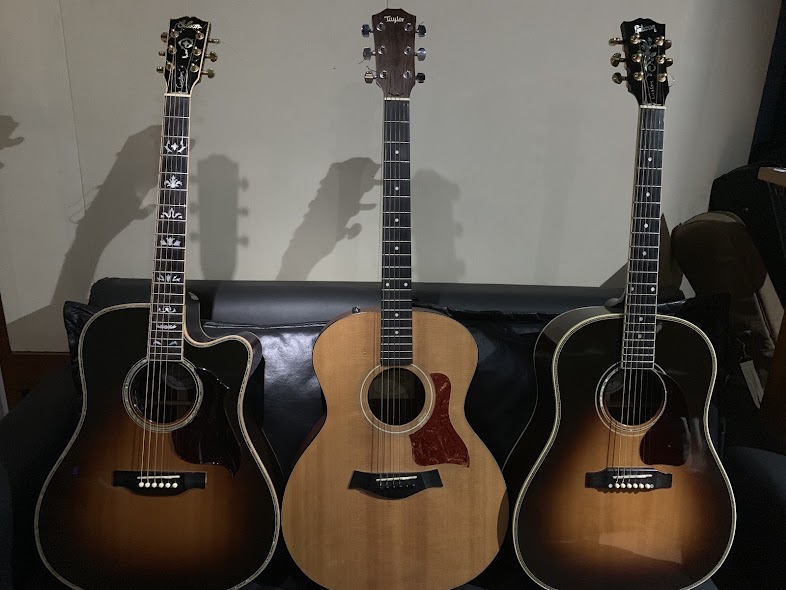Três violões acústicos apoiados sobre o sofá do estúdio