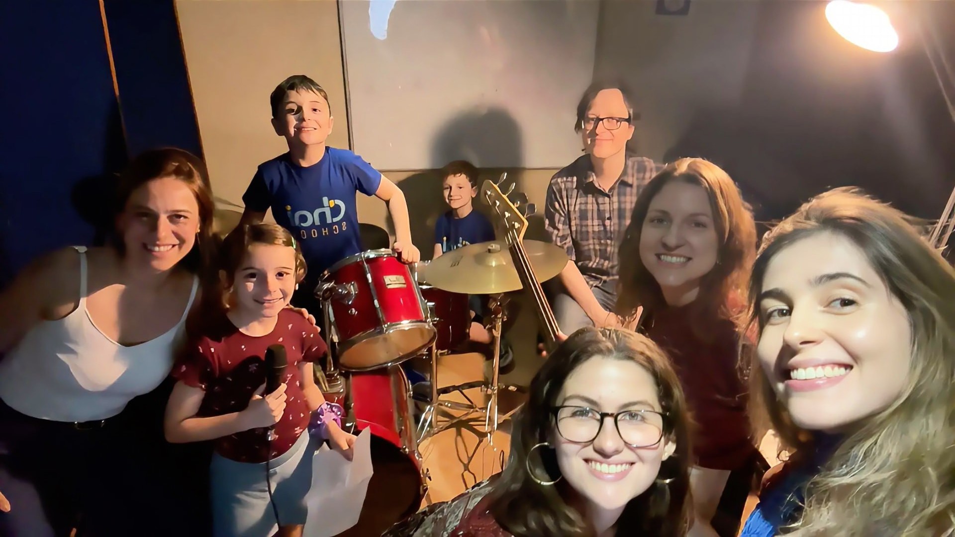 Grupo de alunos e professores com instrumentos no estúdio