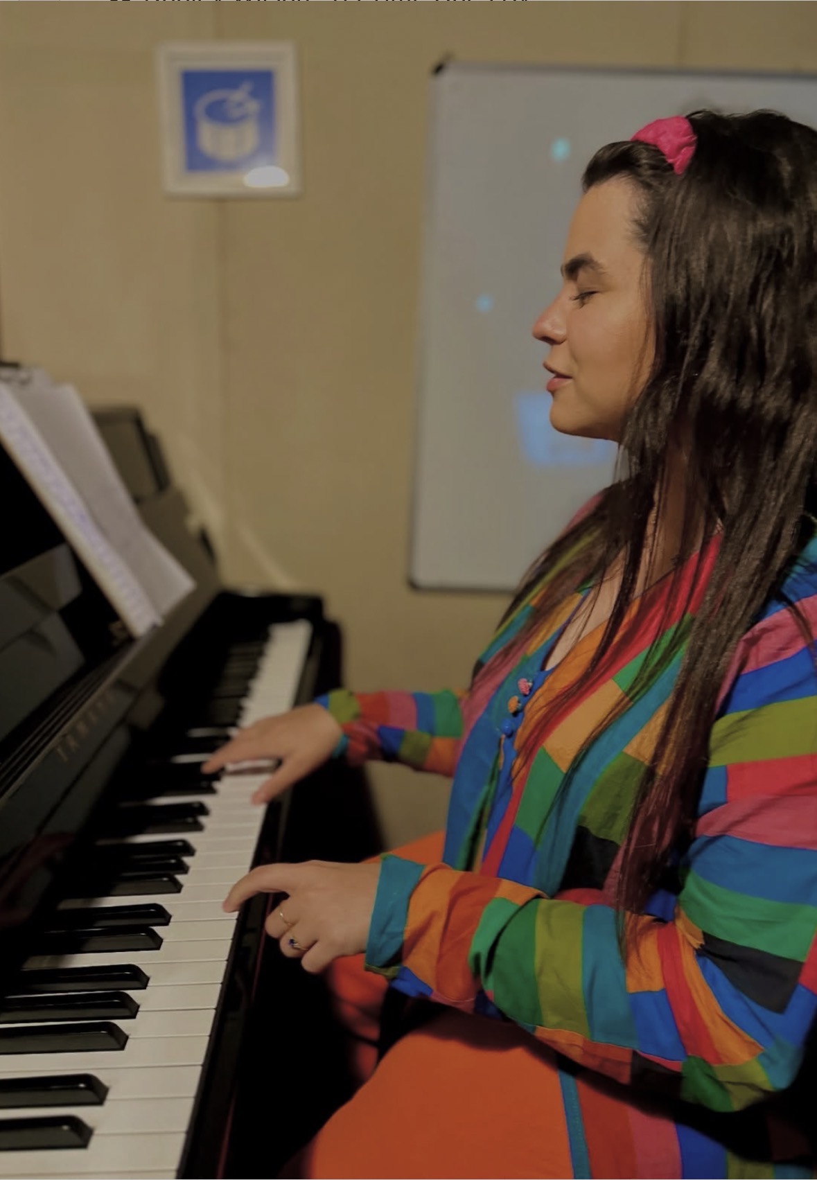 Aluna tocando piano em uma sala de estudo do Centro Musical Downtown